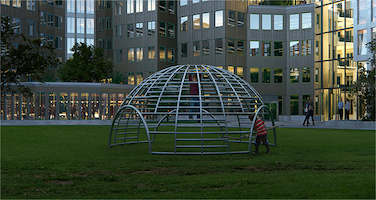 Kid playing in celebrated climbing dome next to Tripolis-Park, both iconic designs by Aldo van Eyck.
